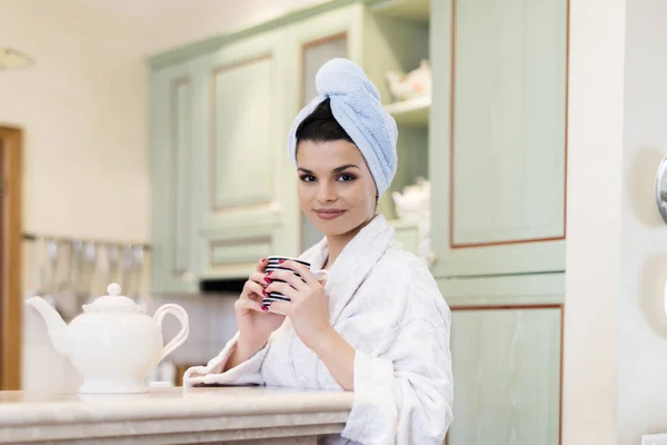 年轻美丽的女人早上在厨房喝茶 — 图库照片