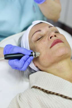Woman receiving Hydrodermabrasion Facial therapy clipart