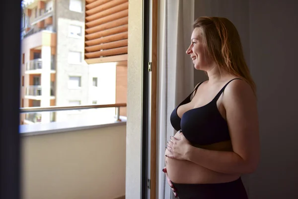 Nachdenkliche Schwangere Schaut Aus Dem Fenster — Stockfoto