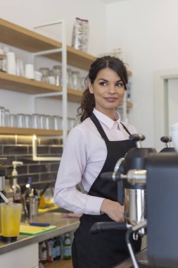 Güzel kadın barista gülümseyen ve kahve dükkanında kahve makinesi kullanarak 