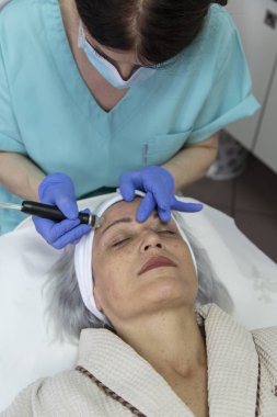 Güzellik kliniğinde yüz tedavisi gören orta yaşlı kadının portresi