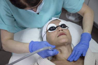 Güzellik kliniğinde yüz tedavisi gören orta yaşlı kadının portresi