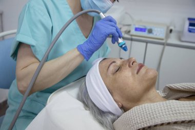 Güzellik kliniğinde yüz tedavisi gören orta yaşlı kadının portresi