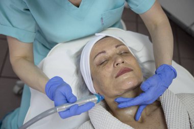 Güzellik kliniğinde yüz tedavisi gören orta yaşlı kadının portresi
