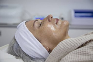 Güzellik kliniğinde yüz tedavisi gören orta yaşlı kadının portresi