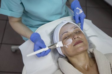 Güzellik kliniğinde yüz tedavisi gören orta yaşlı kadının portresi