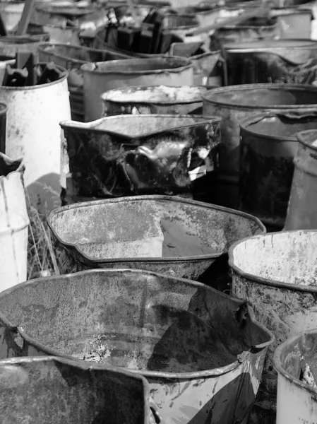 Old, empty and discarded oil drums left to rust in a rural field.