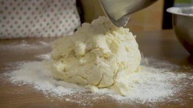 Kapat - eller evdeki masada hamuru yoğur. Elleri mutfakta hamuru hazırlayan bir kadının yakın çekimi.