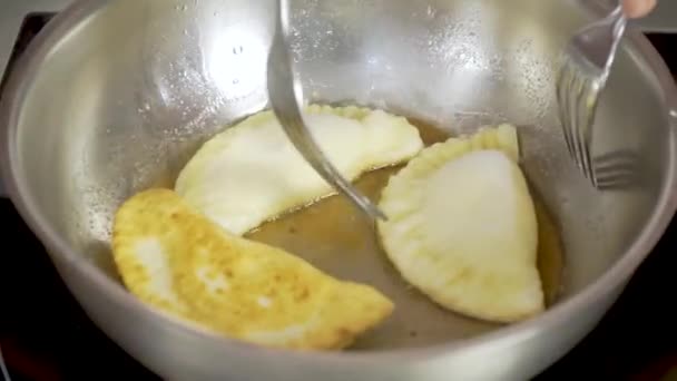 Sequence of fries being fried in heated oil in black pan and stirring them — Stock Video