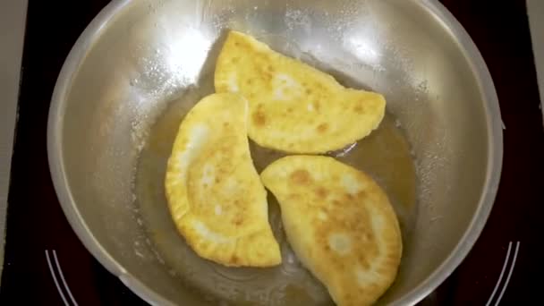 Sequência de batatas fritas fritas em óleo aquecido na panela preta e mexendo-as — Vídeo de Stock