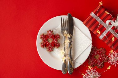 Noel için hediye kutuları, tabaklar, çatallar, bıçaklar ve kalplerle ahşap bir masa..