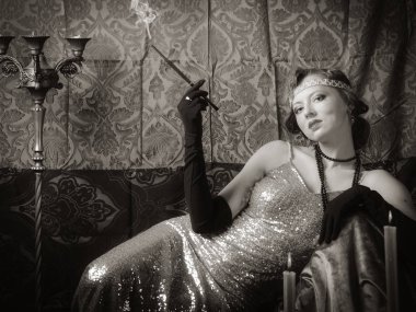 Bir sigara ağızlık ile bir gece elbisesi kız. Stüdyo portre retro tarzı, tonda sepya içinde