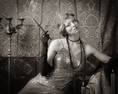 Bir sigara ağızlık ile bir gece elbisesi kız. Stüdyo portre retro tarzı, tonda sepya içinde