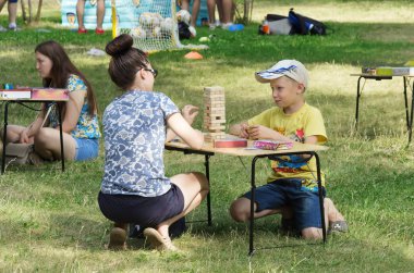 Genç bir anne ile oğlu genel bir parkta masa oyunları oynar. 06/29/2018: Rusya, Orenburg, Perovsky Park Resmin çekildiği. Aile tatilleri