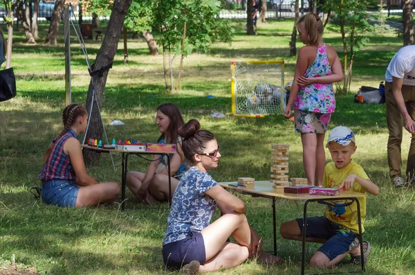 Genç bir anne ile oğlu genel bir parkta masa oyunları oynar. 06/29/2018: Rusya, Orenburg, Perovsky Park Resmin çekildiği. Aile tatilleri