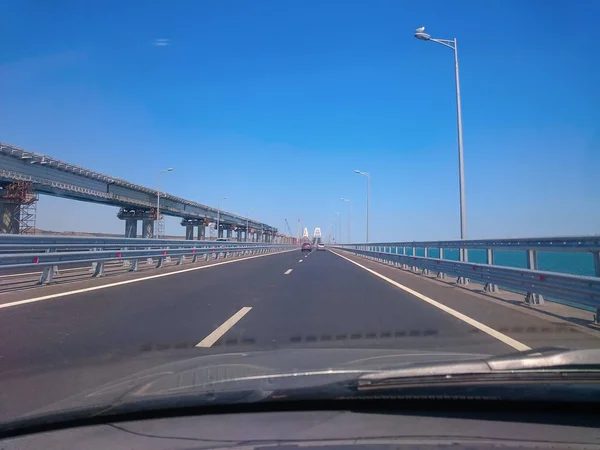 View through the windshield of a moving car. Crimea - June, 8, 2018: Travel on the Crimean bridge during its construction. View from the car