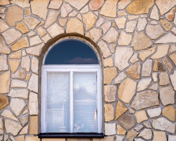 Window on the stone wall background. Orenburg, Russia - April, 22, 2019: Window with reflections in the glass, in the wall of a stone building