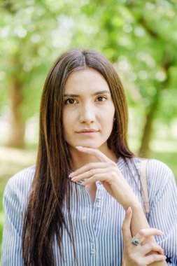 Şehir parkında Asyalı bir kız. Yeşil yapraklı genç Tatar 'ın yaz portresi