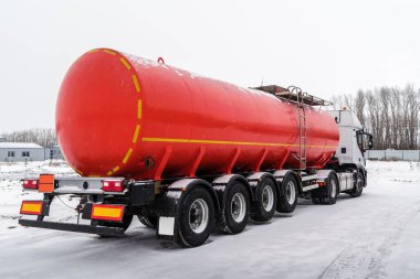Kırmızı tank yarı römorklu bir petrol tankeri. Fotoğraf Rusya 'da çekildi, kışın kar yağarken.