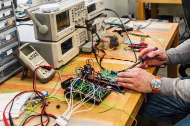 Elektronik Mühendis iş başında. İş aletleri ve ekipmanlar. Fotoğraf fabrikanın teknik bölümünde çekildi.