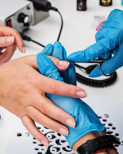 尼尔沙龙Nail Salon 戴蓝色防护手套的主人是用修指甲剪刀工作的 特写镜头 — 图库照片