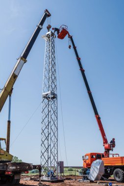 Orenburg, Rusya - 26 Mayıs 2020: İşçiler bir kamyon vinci ve hava platformu kullanarak rüzgar jeneratörü kurdular