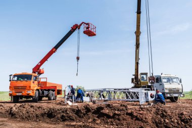 Orenburg, Rusya - 26 Mayıs 2020: Yaklaşmakta olan rüzgar türbininin kurulum alanında inşaat makineleri ve işçiler
