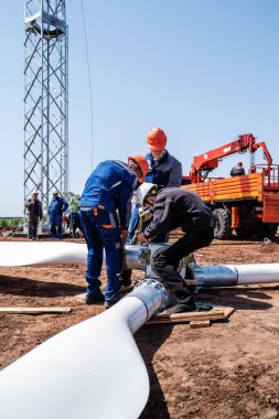 Orenburg, Rusya - 26 Mayıs 2020: Kurulmadan önce rüzgar türbini pervanesi monte eden bir inşaat sahasındaki işçiler