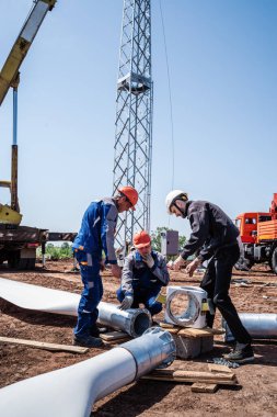 Orenburg, Rusya - 26 Mayıs 2020: Kurulmadan önce rüzgar türbini pervanesi monte eden bir inşaat sahasındaki işçiler