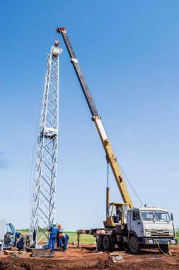 Orenburg, Rusya - 26 Mayıs 2020: İnşaat alanı, inşaat malzemeleri kullanan işçiler rüzgar türbini kulesi kurdular