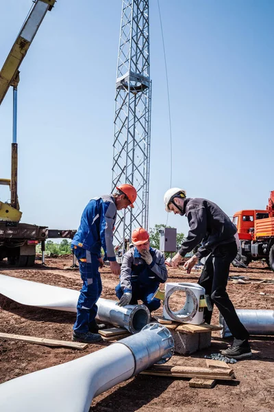 Orenburg, Rusya - 26 Mayıs 2020: Kurulmadan önce rüzgar türbini pervanesi monte eden bir inşaat sahasındaki işçiler