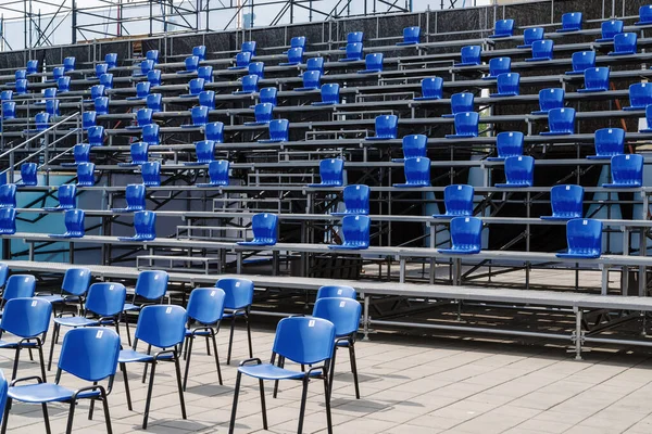 An uncrowded tribune at a mass event, with chairs arranged taking into account social distance. The picture was taken in the summer in Russia, in the city of Orenburg