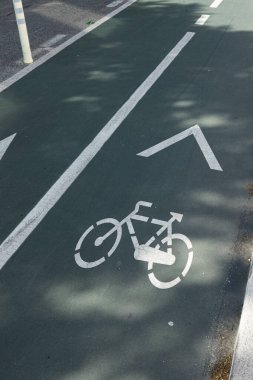 Boyalı bisiklet sembolü ve yön okuyla yeşil bisiklet şeridine yakın plan, kentsel hareketliliği ve sürdürülebilir ulaşımı destekliyor.