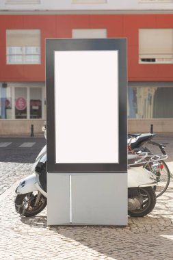 Arka planda scooterların park edildiği bir sokak ortamında boş dikey reklam panosu. Model, pazarlama ve reklam tasarım projeleri için ideal.