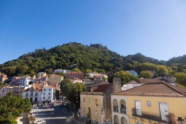 Portekiz, Sintra 'da Moors Kalesi' nin tepesinde yeşil bir tepenin eteğindeki renkli evler ve tarihi mimari..