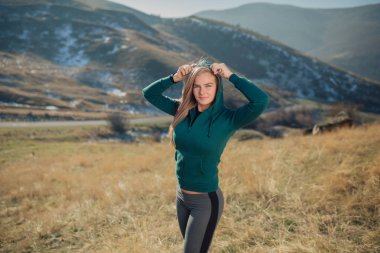 Genç kadın bir dağın tepesinde egzersiz yerleştirmek