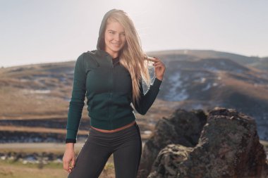 Genç kadın bir dağın tepesinde egzersiz yerleştirmek