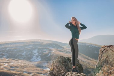 Genç kadın bir dağın tepesinde egzersiz yerleştirmek