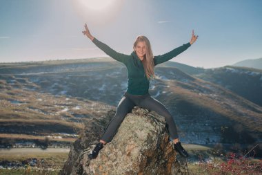 Genç kadın bir dağın tepesinde egzersiz yerleştirmek