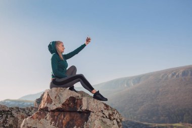 Genç kadın bir dağın tepesinde egzersiz yerleştirmek