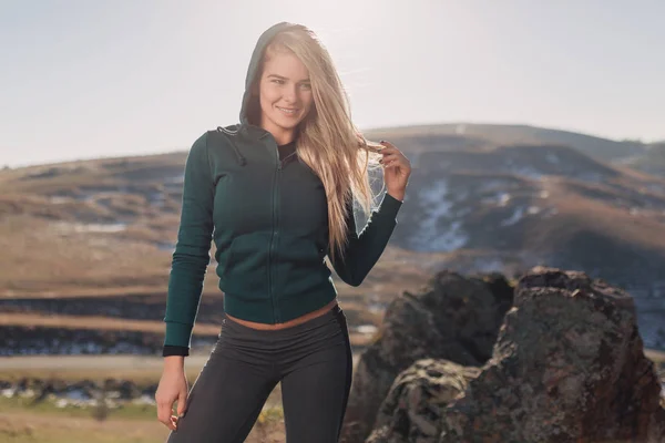 Genç kadın bir dağın tepesinde egzersiz yerleştirmek