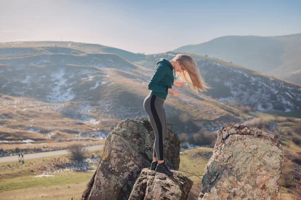 Young fit woman exercising on a mountain top — Stock Photo, Image