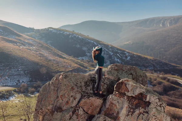 Genç kadın bir dağın tepesinde egzersiz yerleştirmek
