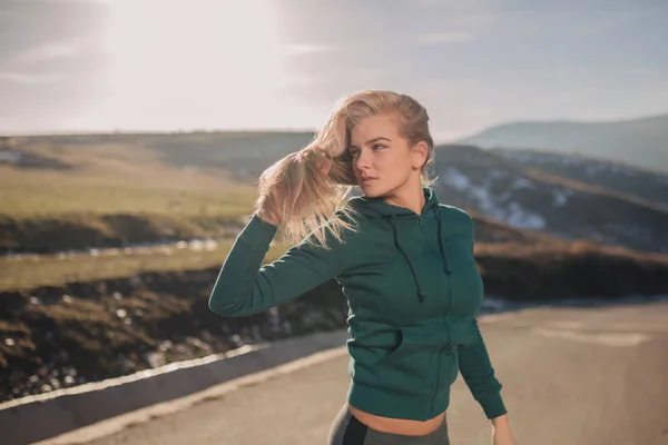 Genç kadın bir dağın tepesinde egzersiz yerleştirmek