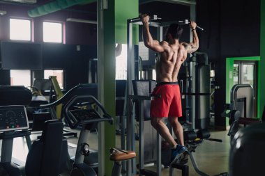 Geri egzersiz yaparak spor salonunda güçlü adam