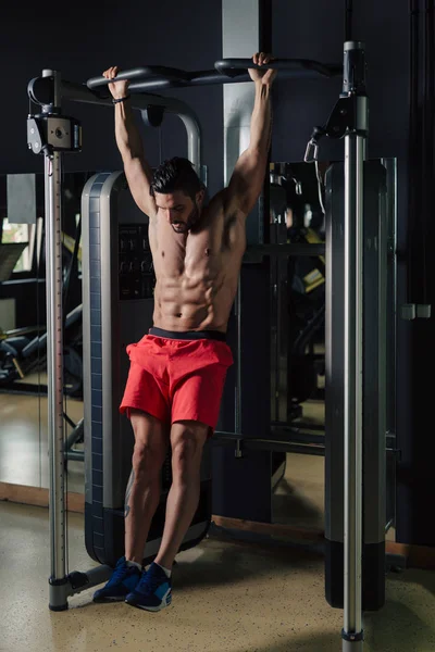 Сильный мужчина в спортзале делает упражнения на прессе — стоковое фото