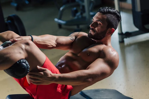 Strong man in the gym doing abs exercises — Stock Photo, Image