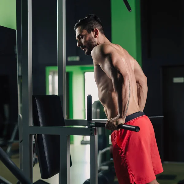 Uomo forte in palestra facendo esercizio tricipiti — Foto Stock