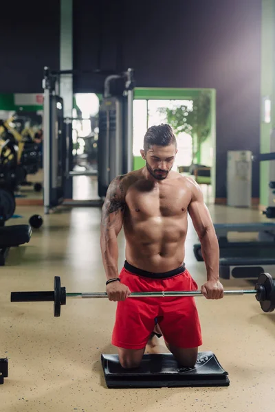 Uomo forte in palestra che fa esercizi di spalla — Foto Stock