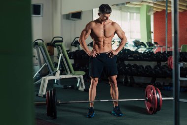 Genç adam jimnastik egzersizleri arasında dinlenme yerleştirmek